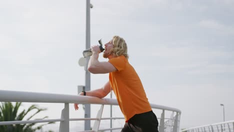 sporty caucasian man drinking water