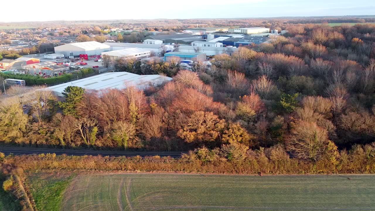 Aerial dolly shot looking over industrial building located in the English countryside, bright sunny day