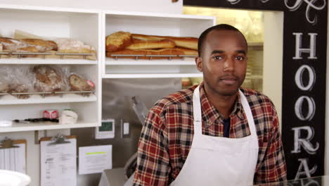 owner behind the counter of sandwich bar crosses arms, shot on r3d