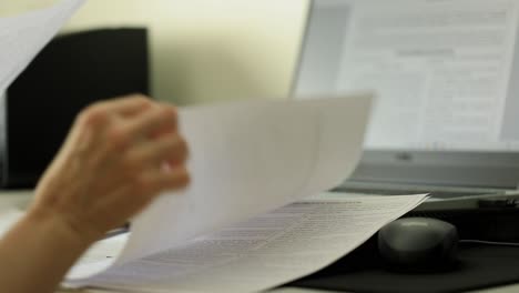 trabajador de oficina comprobando y revisando hojas individuales de papeleo en el escritorio