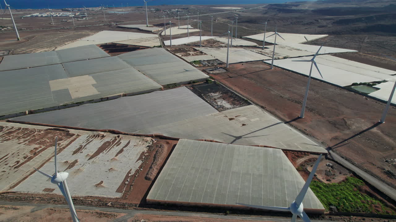 volando sobre un campo de turbinas eólicas en un paisaje desértico en la isla de gran canaria en un día soleado