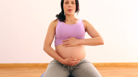 Mujer-Embarazada-Sentada-Sobre-Una-Pelota-De-Ejercicio-Azul