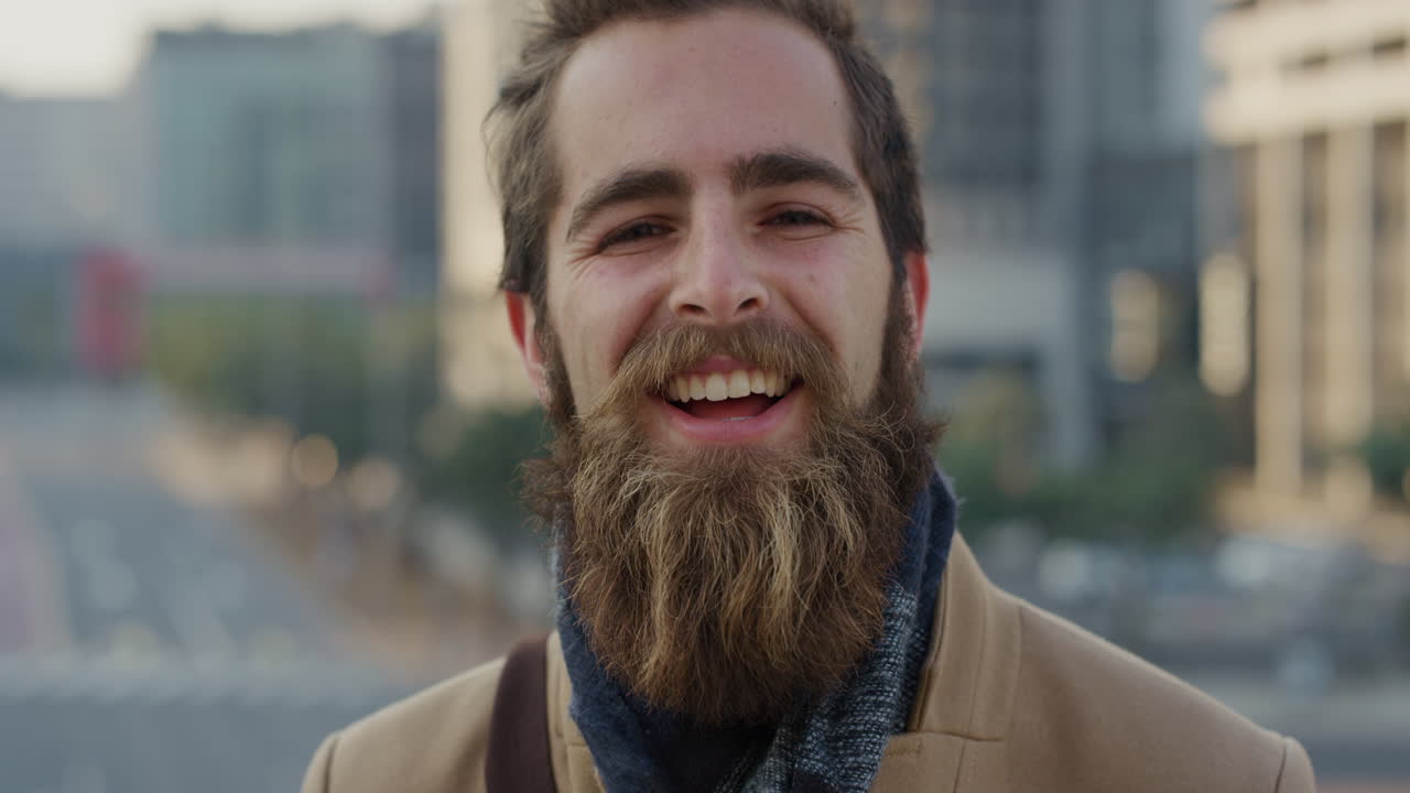 retrato de cerca profesional joven hipster hombre riendo disfrutando de un exitoso estilo de vida urbano feliz empresario barbudo en la ciudad al atardecer en cámara lenta