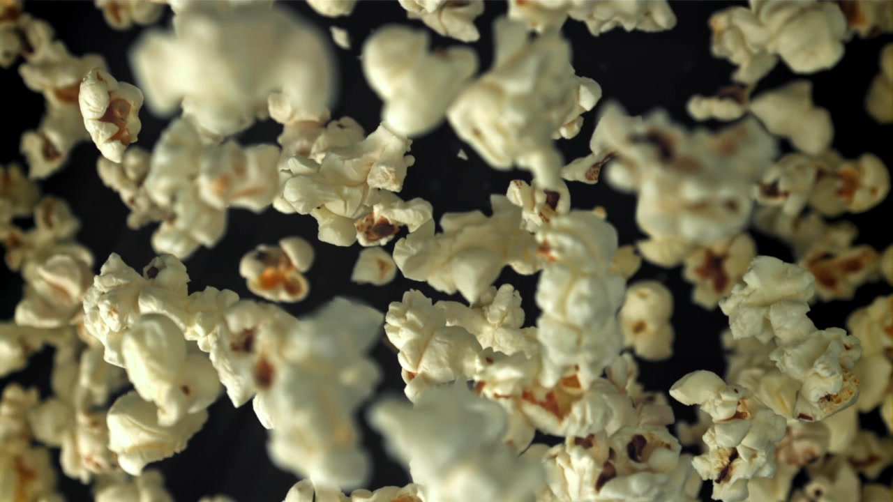 Popcorn che cadono al rallentatore su sfondo nero