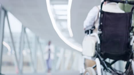 Hospital-corridor,-woman-and-back-in-wheelchair