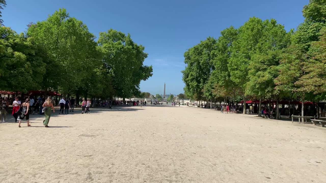 imágenes en lapso de tiempo de personas caminando en el jardín público llamado "jardin des tuileries" en parís. el obelisco en la plaza de la concordia está a la vista.