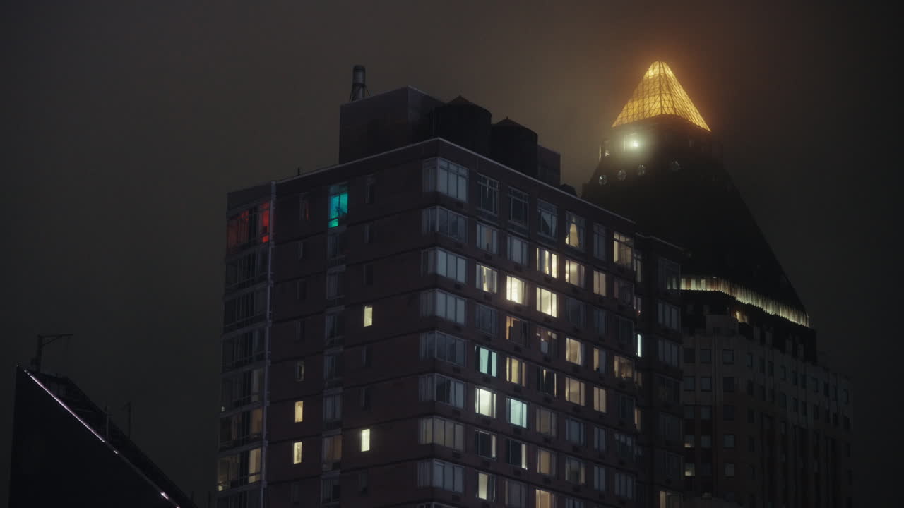 Foggy Night City Skyline with Illuminated Buildings