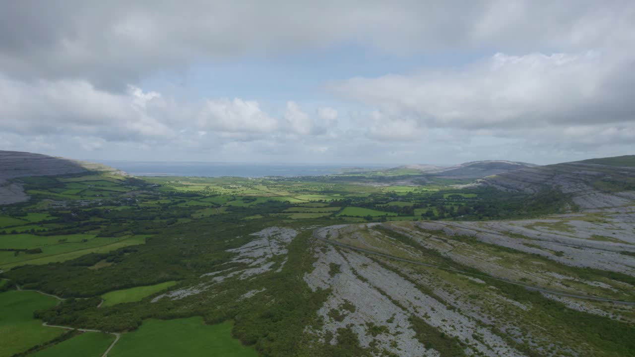 un camino a través de las áridas tierras altas del burren hasta el mar y las exuberantes y verdes tierras de cultivo