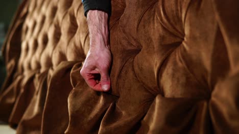 close-up of a person inspecting upholstery on a sofa