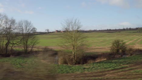 british countryside on sunny day from a moving train