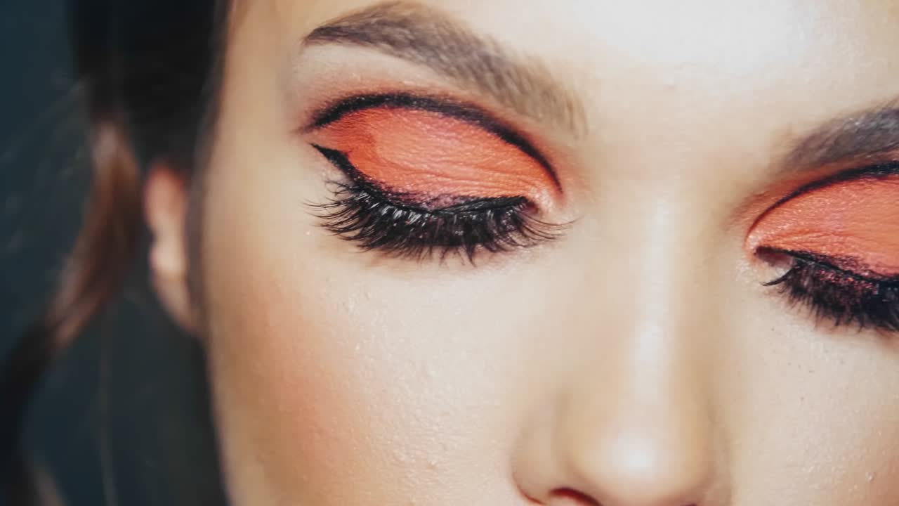 mujer hermosa con pestañas pintadas y párpados parpadeando en cámara lenta