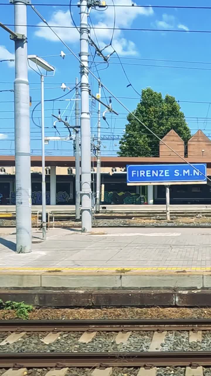 Un tren pasa por una soleada estación de Nápoles