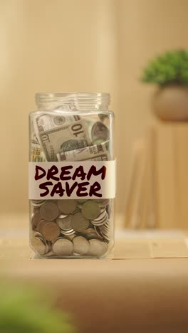 vertical video of person saving money for dream saver