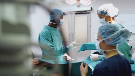 Krankenschwester-überreicht-Dem-Chirurgen-Medizinische-Instrumente,-Während-Das-Operationsteam-Im-Operationssaal-Am-Patienten-Arbeitet