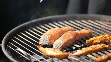 el salmón se está girando en la parrilla con pinzas de parrilla cerca