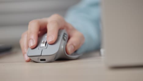 close-up hand of a businessman using wireless or bluetooth mouse. scrolling the wheel working with a pc or laptop.