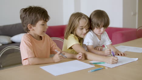 Cheerful-children-painting-with-markers-in-living-room