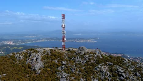 aerial view of telecommunications mast on rocky hillside in miradoiro da curota with ria de arousa in background