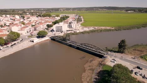 aerial orbiting shot around rodoviaria bridge with traffics crossing sado river and parish townscape