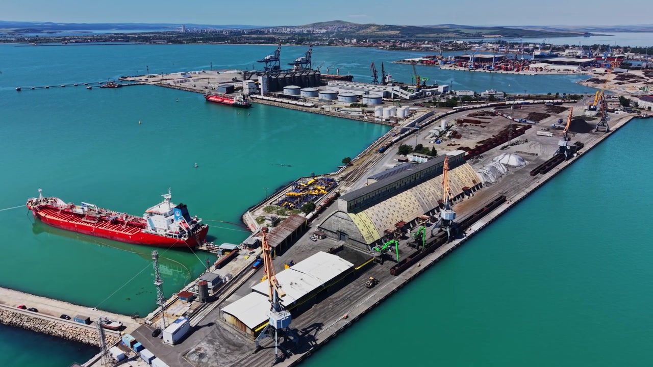 Una nave da carico attracca in un porto industriale per operazioni di carico e scarico.