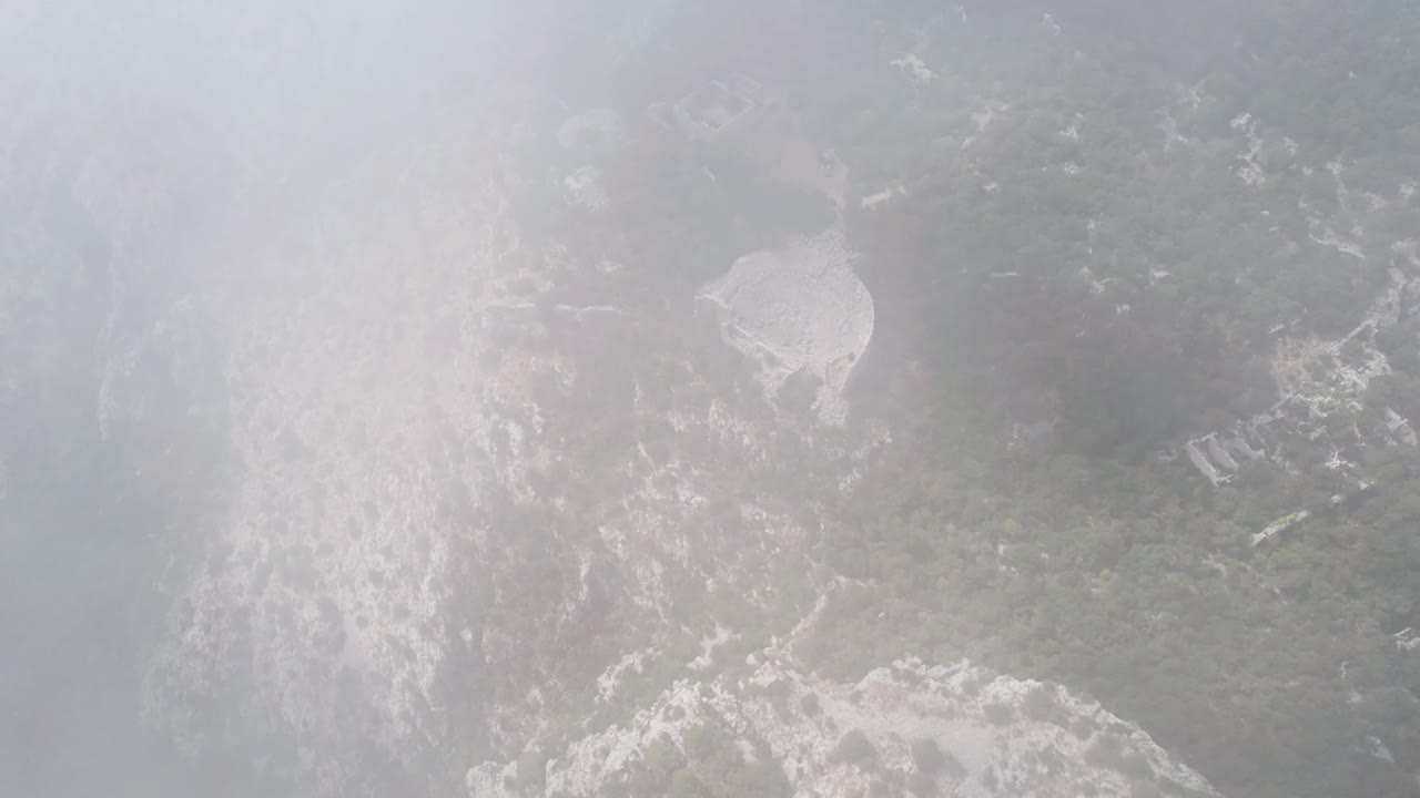 고대 그리스 원형 극장 테메소스, 안탈리아, 터키를 보여주는 흐린 산 공중 드론 샷