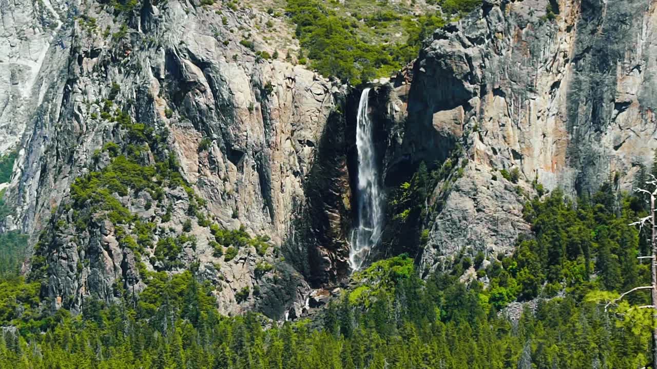 Hermosa toma en cámara lenta de la famosa cascada Bridalveil Fall en Yosemite en un cálido y soleado día de verano en California.