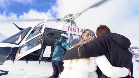 bride and groom boarding helicopter in snowy rocky mountains