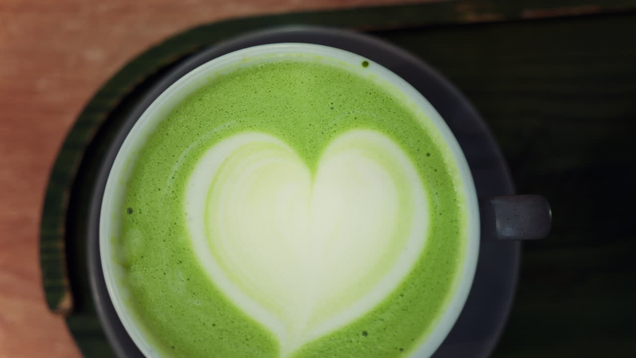 Close up of a matcha latte on a black tray at a cafe