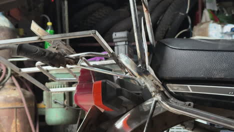 close-up of blue-gloved hand welding a metal bar with bright sparks and protective gear.
