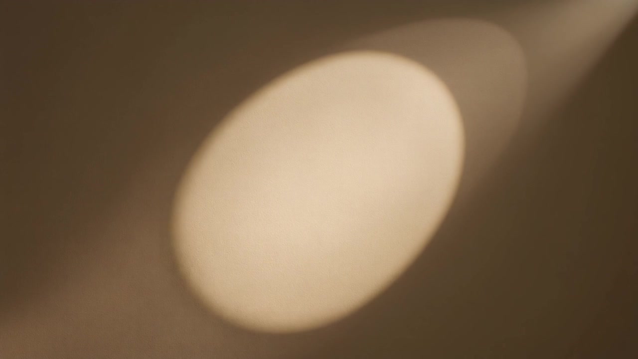 Feixe de Holofote Movendo-se por uma Parede Bege Lisa