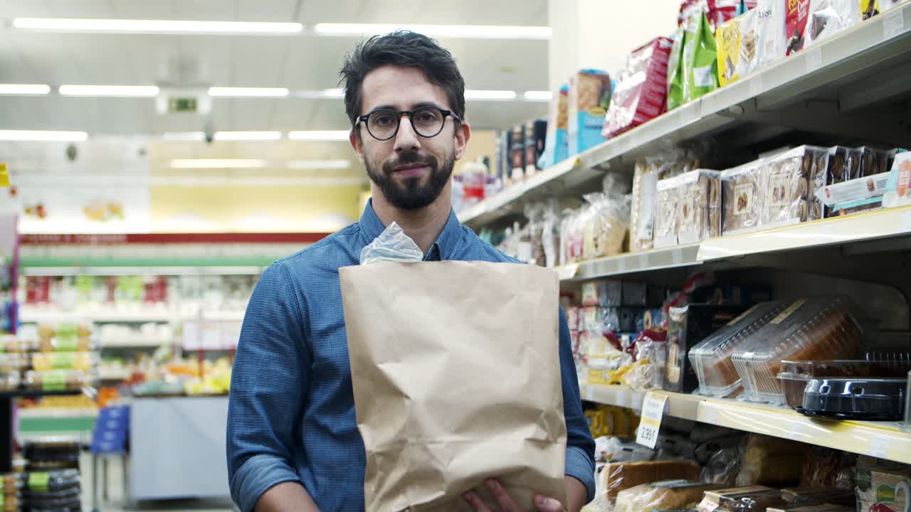 joven con una bolsa de papel en un supermercado