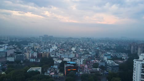 aerial drone shot showcasing the peaceful morning view of delhi, with skyscrapers and historic landmarks illuminated under the cool blue hues of dawn.