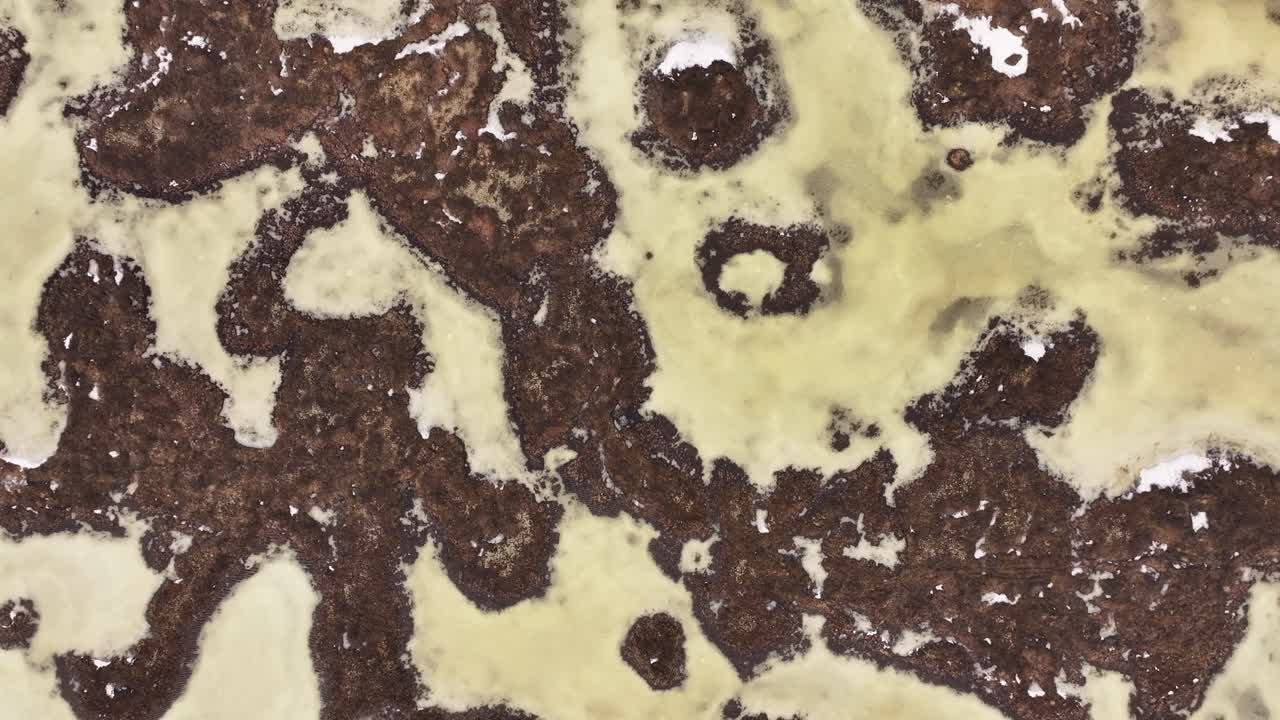 Top-down aerial view of Iceland’s Reykjahlíð region reveals the surreal patterns of frozen Lake Mývatn and surrounding volcanic terrain, blending natural abstraction with raw geothermal beauty.