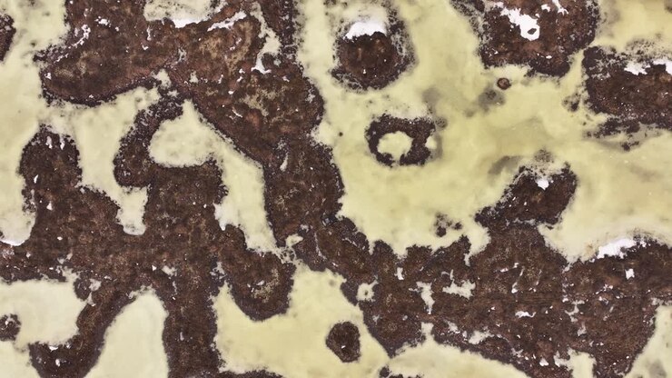 Vista aerea dall'alto della regione di Reykjahlíð in Islanda rivela i motivi surreali del lago ghiacciato Mývatn e del terreno vulcanico circostante, fondendo l'astrazione naturale con la pura bellezza geotermica.