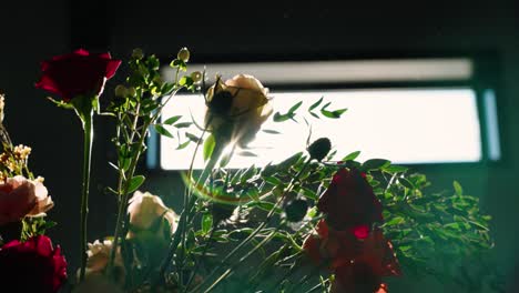 a dramatic close-up shot of floral arrangements with roses and greenery, backlit for a striking silhouette effect. captured at a south georgia fall wedding