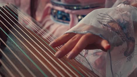 una chica china jugando al guzheng afuera.