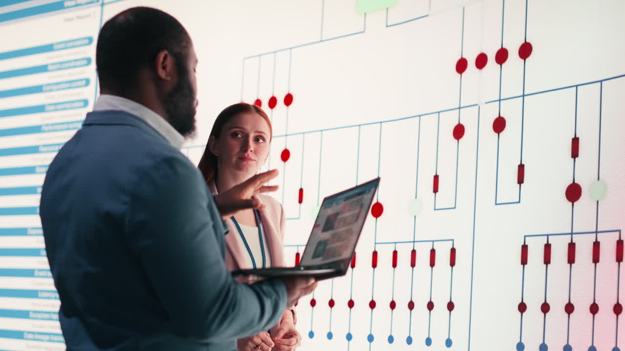 Business Professionals Discussing Data on Large Digital Screen