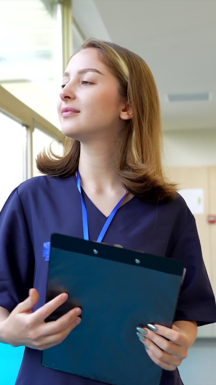 Nurse with clipboard in hospital corridor