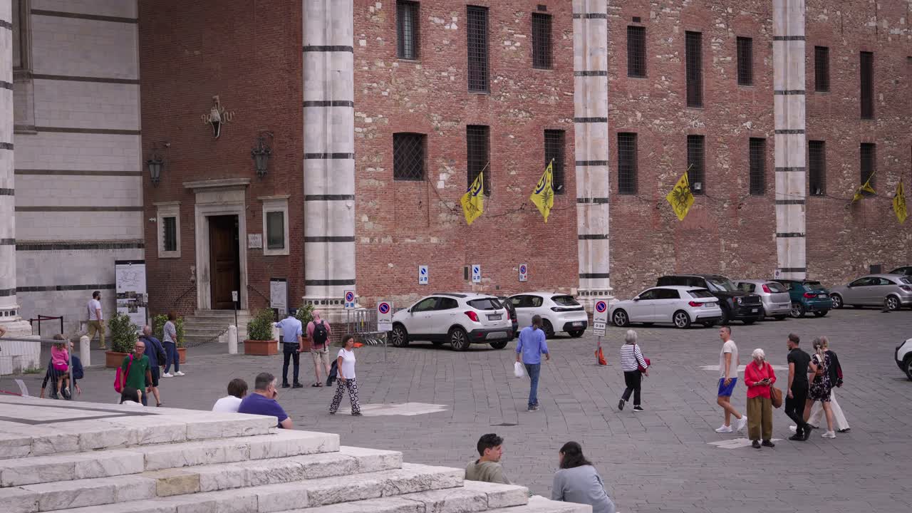 People walking in front of a church in Siena, Italy