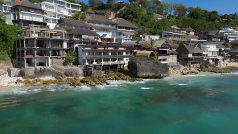 bingin beach pull away revealing surfers and limestone cliff resorts