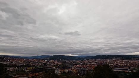 las nubes se precipitan sobre la histórica ciudad de ourense, galicia, españa, mientras los coches conducen por la autopista y la carretera.