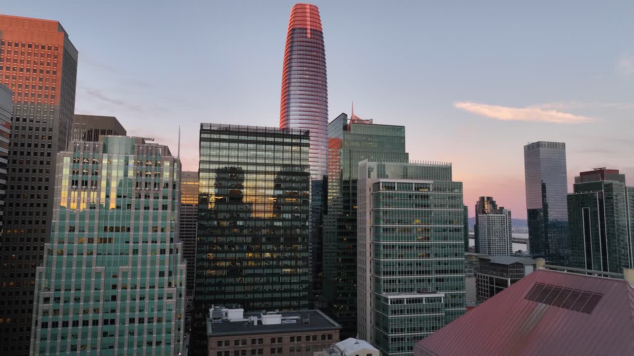 창문과 만의 전망에 해가 지는 반사와 함께 세일즈포스 타워를 향한 항공