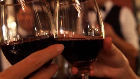 manos de una pareja brindando copas de vino