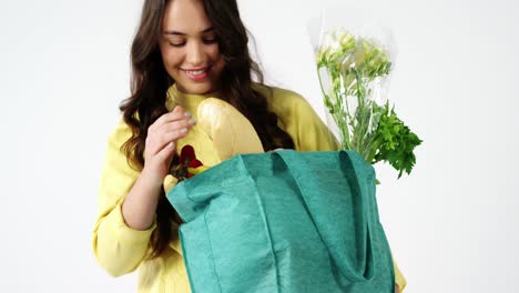 retrato de una mujer sonriente con una bolsa de comestibles