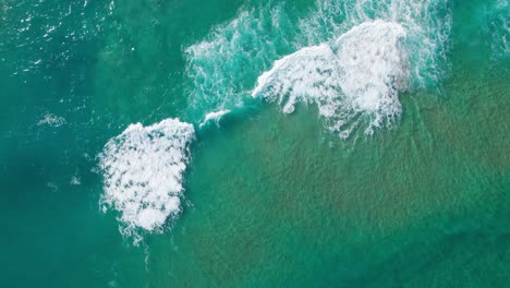 topview zoom out push out of perfect waves at sea washing white waters to shore, mesmerizing wave ocean topview at playa de tagle, wide oceanic top view in spain coast