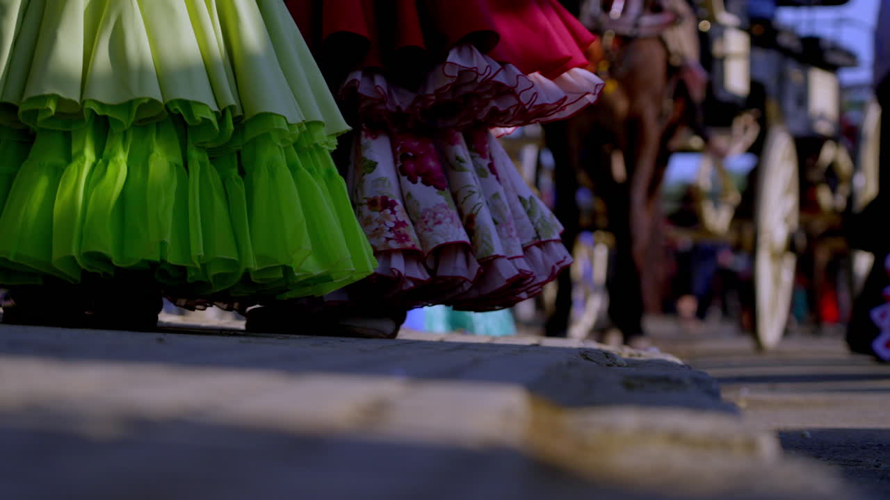 unique Colorful flamenco skirts walking past carriages in a traditional Sevillian parade