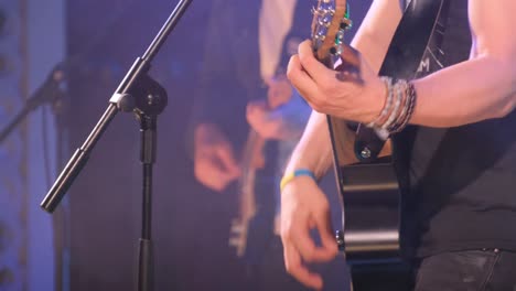 jazz guitarist musician playing acoustic guitar in a night club. the man uses his hands to play this instrument, which gives her the ability to play the guitar.