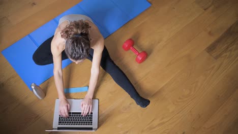 anonymous sportswoman watching video lesson on computer at home