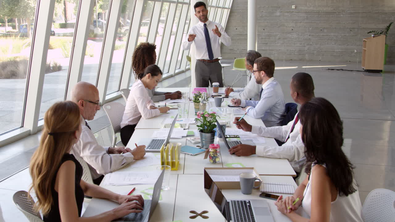 hombre de negocios liderando una reunión en la mesa de la sala de juntas filmado en r3d