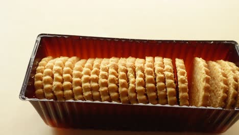 un primer plano de una caja de galletas redondas y doradas